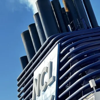 A Norwegian Cruise Line ship prominently displays a large sign featuring the letters "NCL" in bold, eye-catching typography.